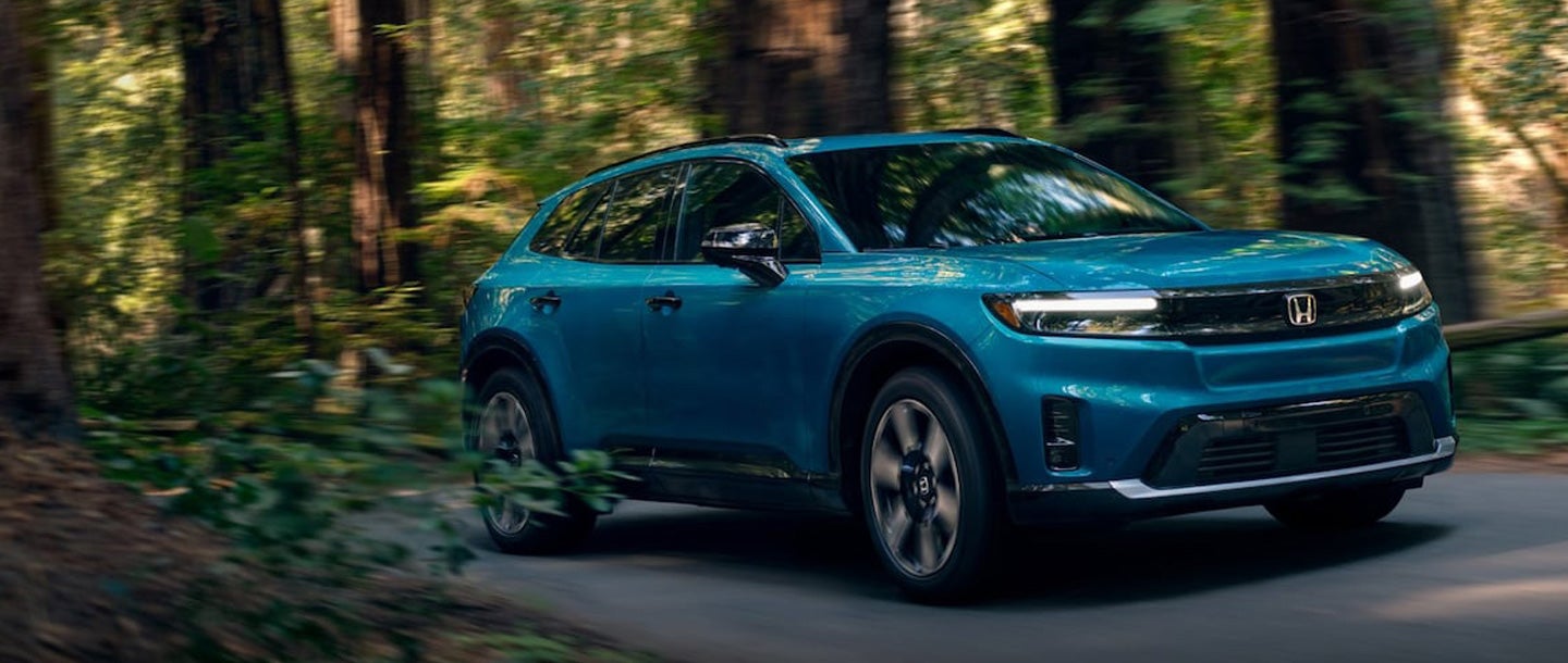 Honda side view driving through forest route