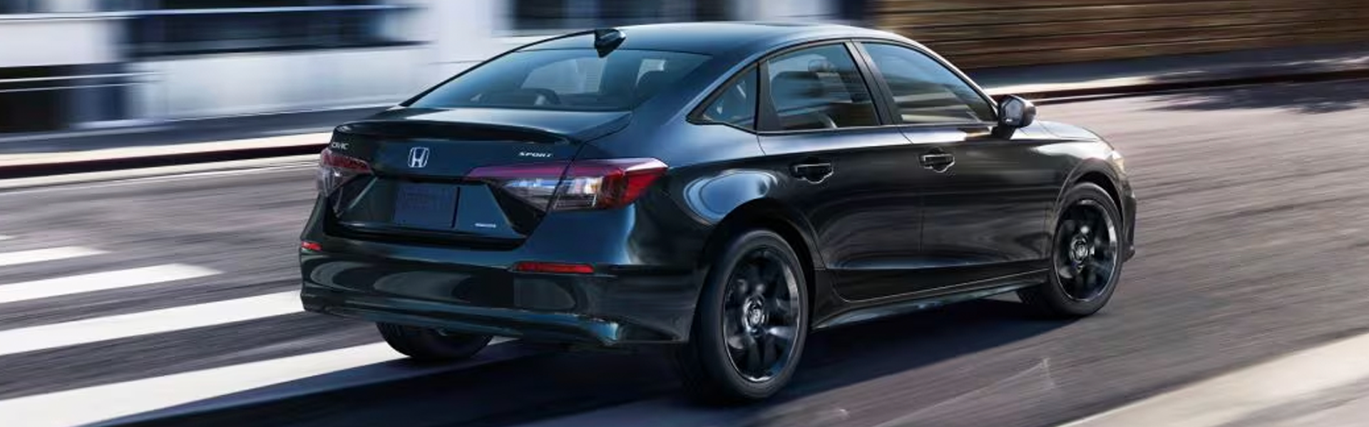 Black 2026 Honda Civic Sedan driving on the road